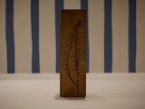 a wooden block with a plant on it on a table