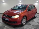 La Volkswagen Golf rouge est garée sur un sol carrelé à damier.