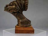 statue of a woman ' s head on a wooden base on a clear acrylic base