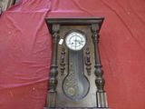 une horloge en bois posée sur un tissu rouge