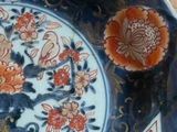 a blue and red plate with flowers on it on a wooden table