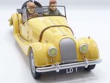 a yellow toy car with a man and a woman in it