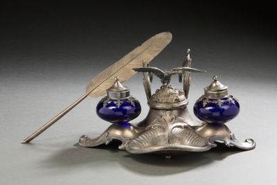 a silver plate with a pen and inkwell on it