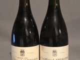 two bottles of wine sitting on top of a table next to each other