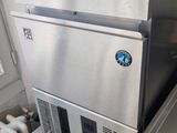 un réfrigérateur en acier inoxydable situé à côté d'un évier et d'un radiateur