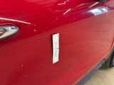 a close up of a red car with a sticker on it