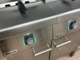 two deep fryers sitting on the counter in the kitchen
