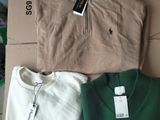 three men ' s sweaters are sitting on a cardboard box