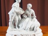 une figurine représentant un homme et une femme assis sur une table