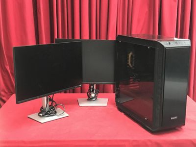 deux écrans d'ordinateur posés sur une table recouverte d'une nappe rouge