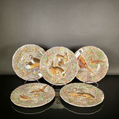 trois assiettes ornées d'oiseaux et de fleurs, posées sur une table