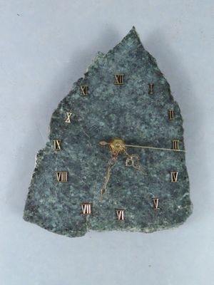 une horloge en pierre sur laquelle figurent des chiffres romains