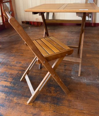 une table et une chaise en bois dans une pièce avec du parquet