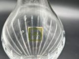 a clear glass vase with a green label on it