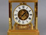 a gold clock with roman numerals on it
