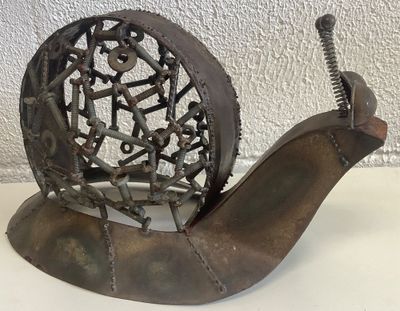 une sculpture représentant un escargot, réalisée à partir de pièces métalliques, posée sur une table