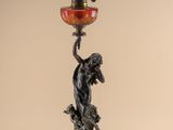 a statue of a woman holding a lamp on top of a table