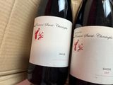 two bottles of wine sitting in a box on a table