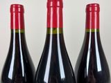 three bottles of wine sitting on top of a table next to each other
