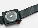 a black watch with a black leather band on a white surface