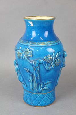 un vase bleu posé sur une table, sur fond gris