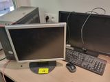 two computer monitors sitting on a desk with a keyboard and mouse