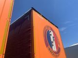 a large orange truck that is parked on the side of the road