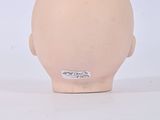 a small head of a doll on a white surface