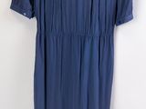 blue dress hanging on a hanger against a white wall