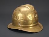 brass fireman ' s helmet on a gray background with a black background