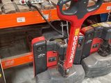 a red and black machine that is sitting in a warehouse