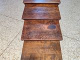 three wooden tables stacked on top of each other on a tiled floor