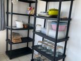 a black shelf with dishes on it in a kitchen