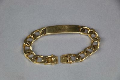 gold plated bracelet with a clasp on a white background