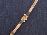 a close up of a watch on a blue surface