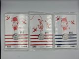 three commemorative coins are in plastic bags on a white surface