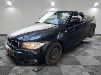 une photo d'une BMW décapotable noire garée sur un sol à damier