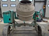 a cement mixer sitting on a dolly in a garage