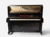 an old black piano sitting on top of a white floor