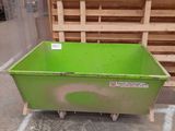 a green container sitting on the floor next to pallets