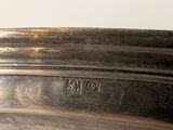 a silver plate with a silver handle on a table
