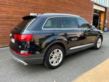 une photo d'un SUV Audi noir garé devant un immeuble