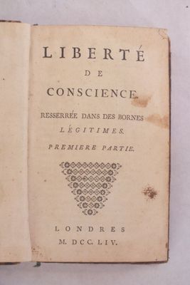 un vieux livre ouvert sur une surface blanche