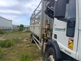 un camion garé dans l'herbe près d'un bâtiment