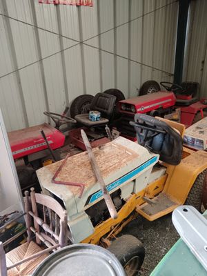 many different types of tractors parked in a garage