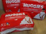 three packs of huggies diapers sitting on top of a wooden table