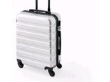 une valise blanche à roulettes sur fond blanc
