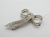 broche en forme de nœud ornée de pierres en cristal sur fond blanc