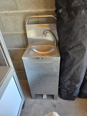 un chien qui se tient devant un évier