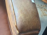a brown leather couch sitting in a room next to a dresser